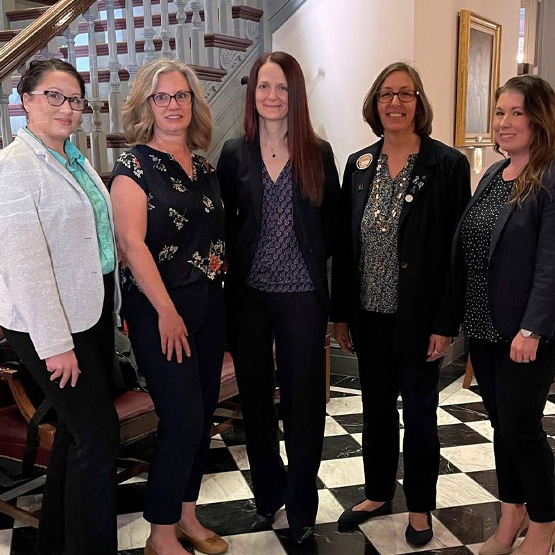 A group of five women from DVCC, DCADV, and CLASI pose inside Legislative Hall.